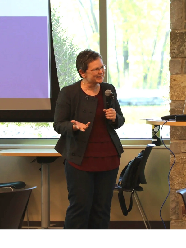 Paula facilitating a workshop with open hand gesture and smile