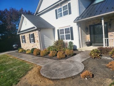 Newly laid concrete walkway and patio area in front of house.