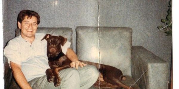 This image shows a person sitting on a sofa with a dog