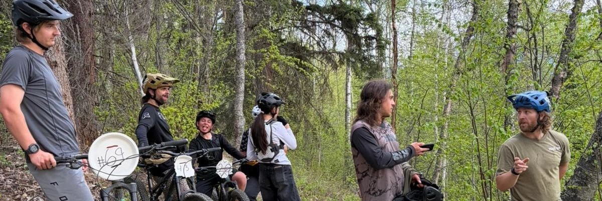 Group of mountain bikers chatting in a forest.