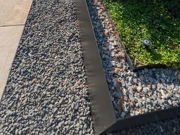 Metal edging with gravel creates a clean, modern landscape border.