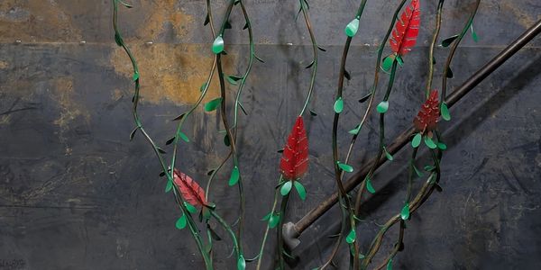 Artificial flowers climbing a metal pipe on a wall.