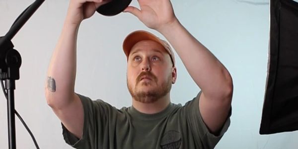 Man adjusting a light in a photography studio.