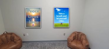 A calm room with two inspirational posters and brown cushioned chairs.