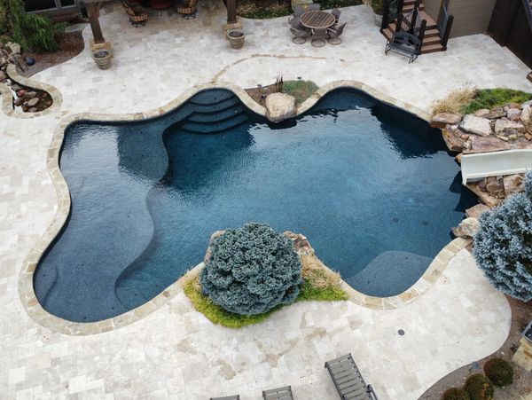 Contemporary custom swimming pool with spa features and water elements.