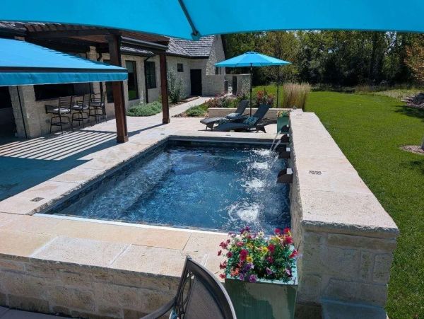 Modern outdoor spa with lounge chairs and umbrellas.