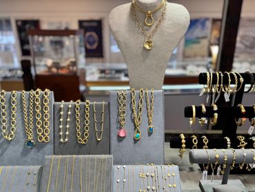 Elegant gold jewelry displayed on stands in a boutique.