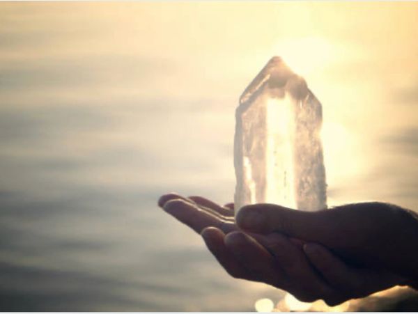 Open hand holding a Quartz Crystal which is used in Crystal Healing Therapy