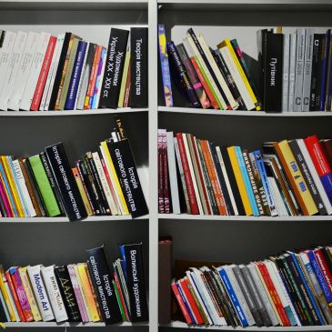 Bookshelves filled with various books and magazines, some titles in Cyrillic script.