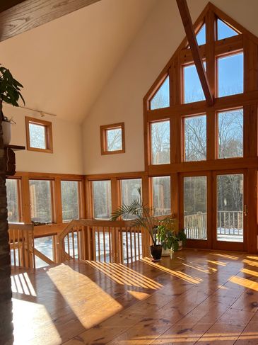 Sunny room with wall of windows and clean wood floor.