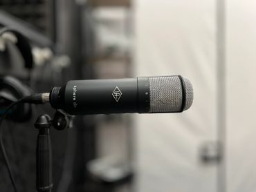Close-up of a studio microphone with a blurred background.
