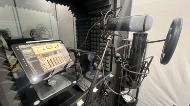 A professional recording setup with microphones and a tablet showing audio controls.