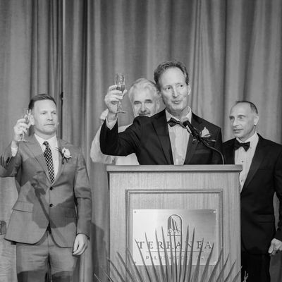 Men raising glasses in a celebratory toast at a formal event.