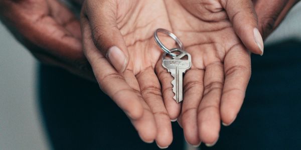 Hands holding a key on a keyring.