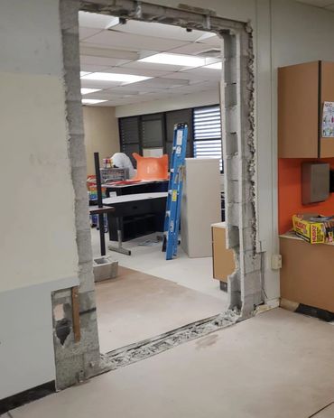 A partially demolished doorway in an office under renovation.