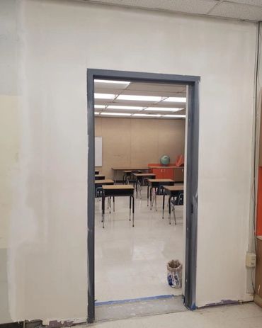 A classroom seen through an unfinished doorway without a door.