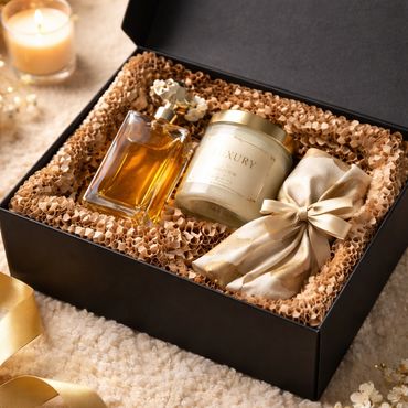 A luxury gift box with perfume, candle, and satin pouch.