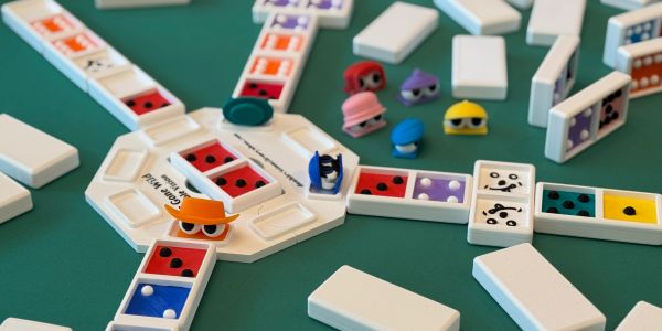 Dominoes game with two colored pieces on a green table.