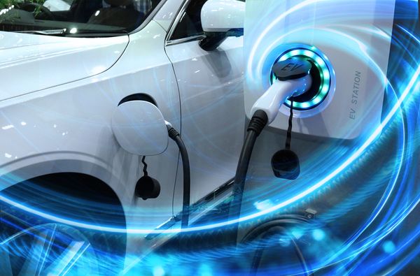 Electric vehicle plugged into an electric vehicle charger station.
