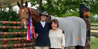 Brawley Farms owner and horse trainers receive championship ribbon at horse show.