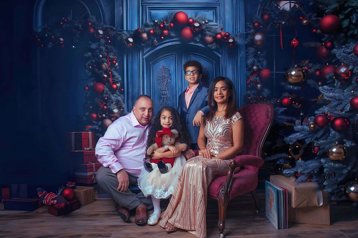 Family portrait with Christmas decorations and gifts.