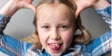 Headshot of one of our young Brand Ambassadors. She's sticking her tongue out, hands on her head.