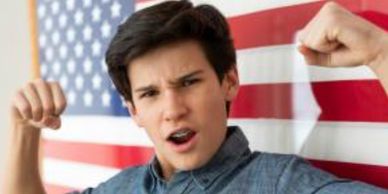 A headshot of a young Brand ambassadors-he's in front of a U.S. flag, looking strong.
