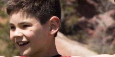 Our Brand Ambassador, Kaden, he's outside and smiling away from the camera.