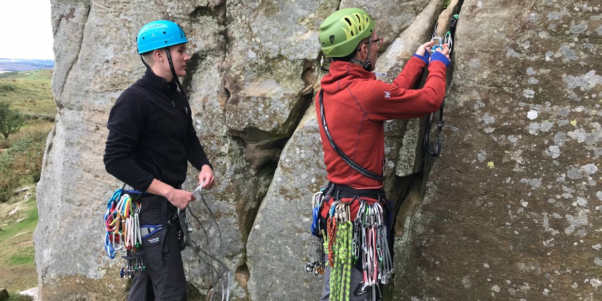 Climbing instructor trainees placing lead protection on a rock climbing instructor course