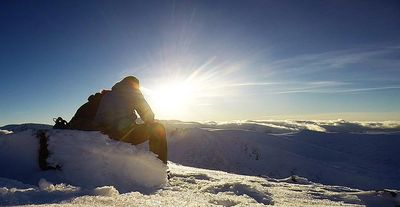Two winter walkers in the mountains on snow using ice axe and crampons on a winter skills course