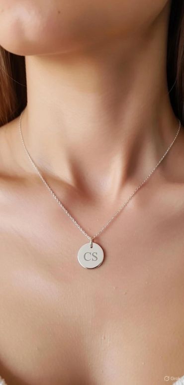 Silver necklace with CS pendant on a woman's neck.