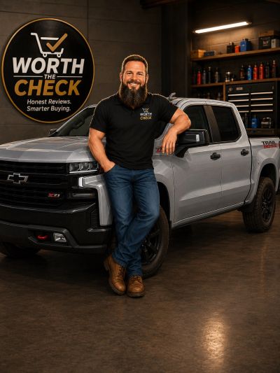 Man leaning on silver Chevrolet truck inside a garage.