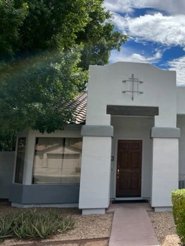 Modern white house with a wooden door and well-kept shrubs.