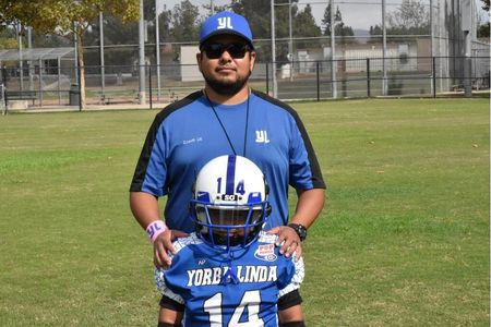 Coach Ulises and his son before a game with the Yorba Linda Pop Warner Giants