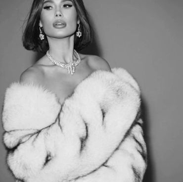 Elegant woman in a luxurious fur coat and statement jewelry.