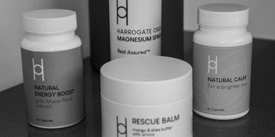 Four natural health products including energy boost, calm capsules, magnesium spray, and rescue balm.