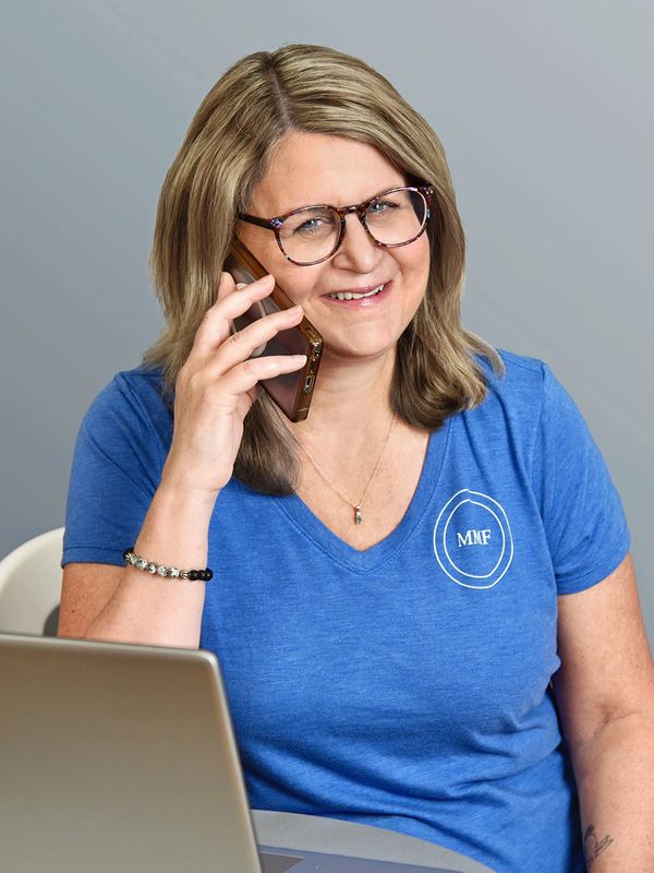 Melissa Ferrara, owner of MMF Business Solutions, talking on the phone and smiling.