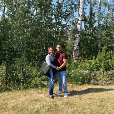 A man and a woman holding hands in the trees