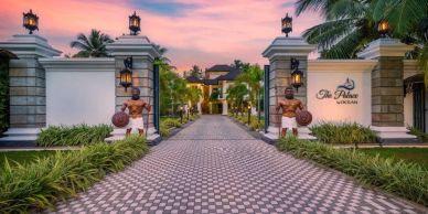 Elegant gated entrance to a luxurious resort at sunset.