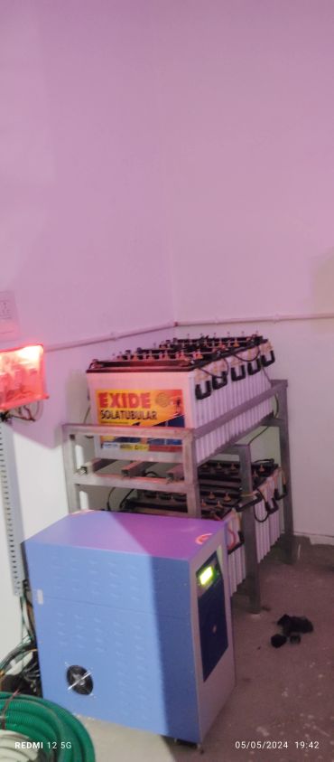 Battery bank setup with Exide Solar Tubular batteries and blue inverter unit.