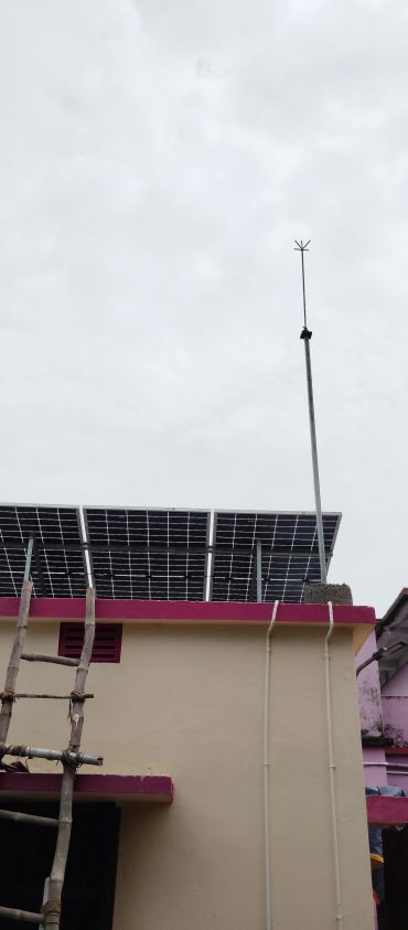 Solar panels installed on a rooftop with a wooden ladder and a tall antenna.
