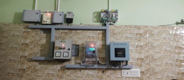 Electrical control panels and meters mounted on a tiled wall.