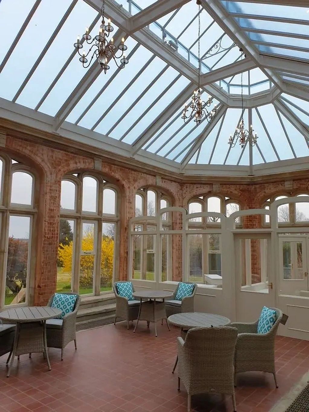 Victorian Orangery with wicker chairs and tables in the foreground and temporary timber screen formi