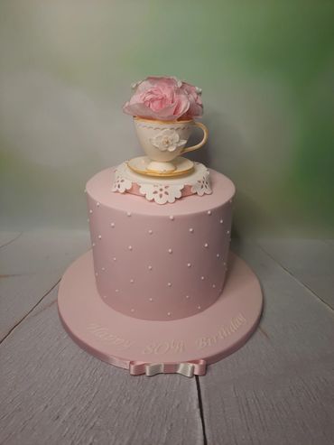 pink cake with teacup topper