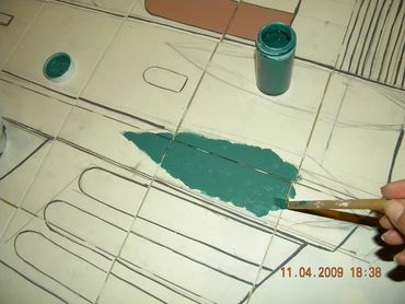 A hand is painting a tree