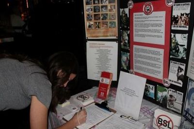 Person signing petition at advocacy booth.
