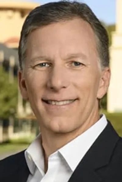 Smiling man in business attire outdoors.