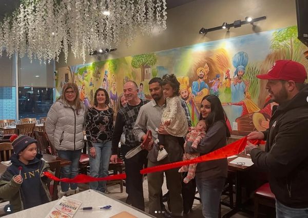 Family and friends gather for a ribbon-cutting ceremony.