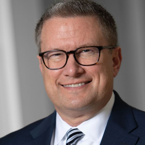 Professional man in glasses wearing a suit and striped tie.