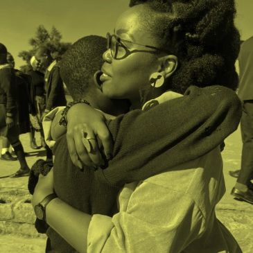 Two people sharing a heartfelt hug outdoors.